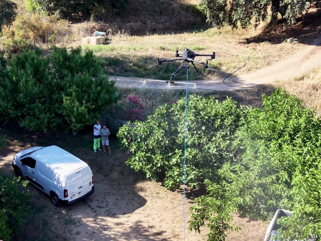 Les deux associés de Drone Solution Pro Corse au sol pendant une intervention de leur drone de pulvérisation